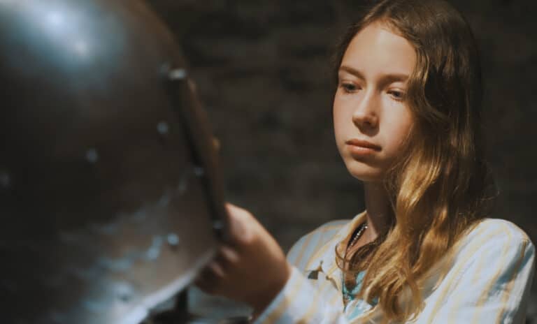history curriculum - teen girl looking at armor