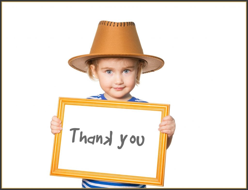 thankfulness project - child holding hand written thank you sign