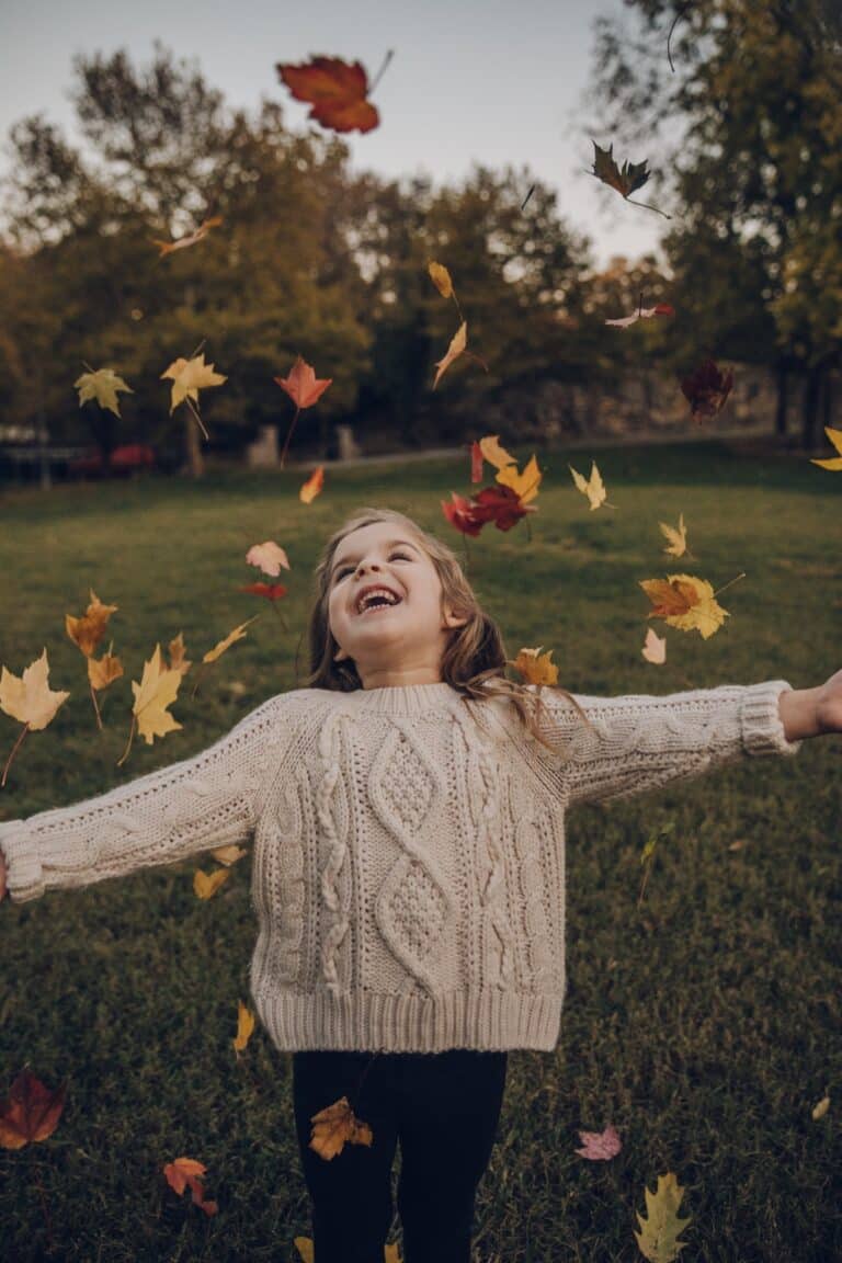 Unit Studies for Homeschoolers - girl tossing leaves into the air
