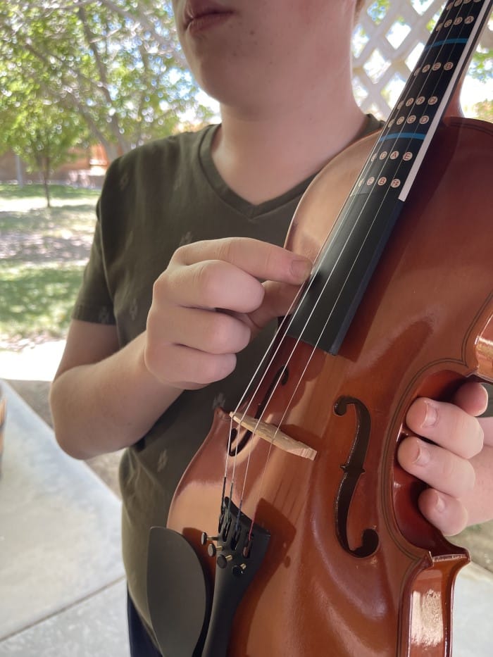 The Suzuki Method - a close-up of a child holding a violin
